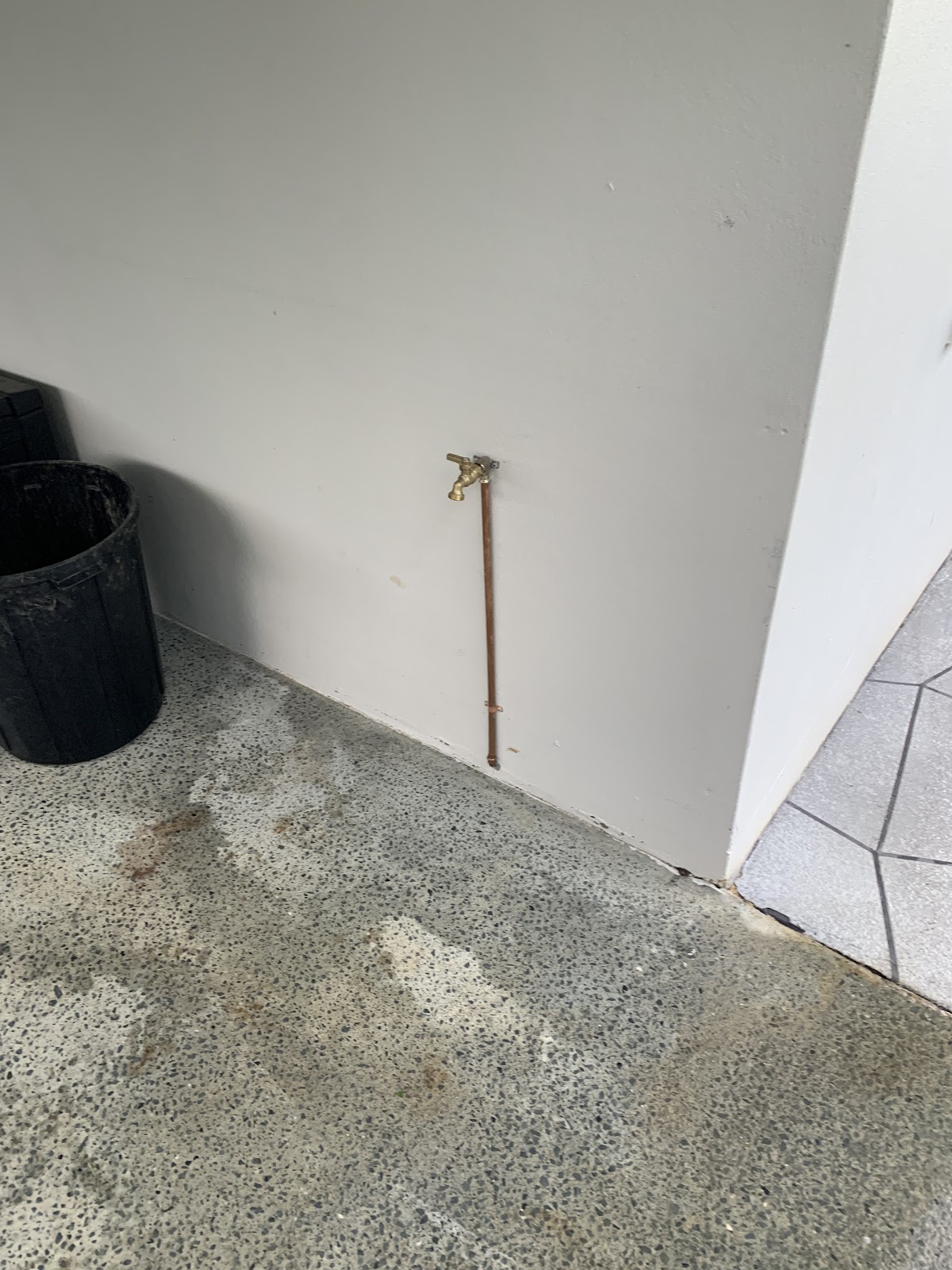 A new outdoor hose tap on a copper line against a painted wall